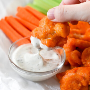 These vegan & gluten-free buffalo cauliflower wings are a game day hit! Crispy cauliflower florets tossed in a spicy buffalo sauce are a party appetizer that everyone can enjoy.