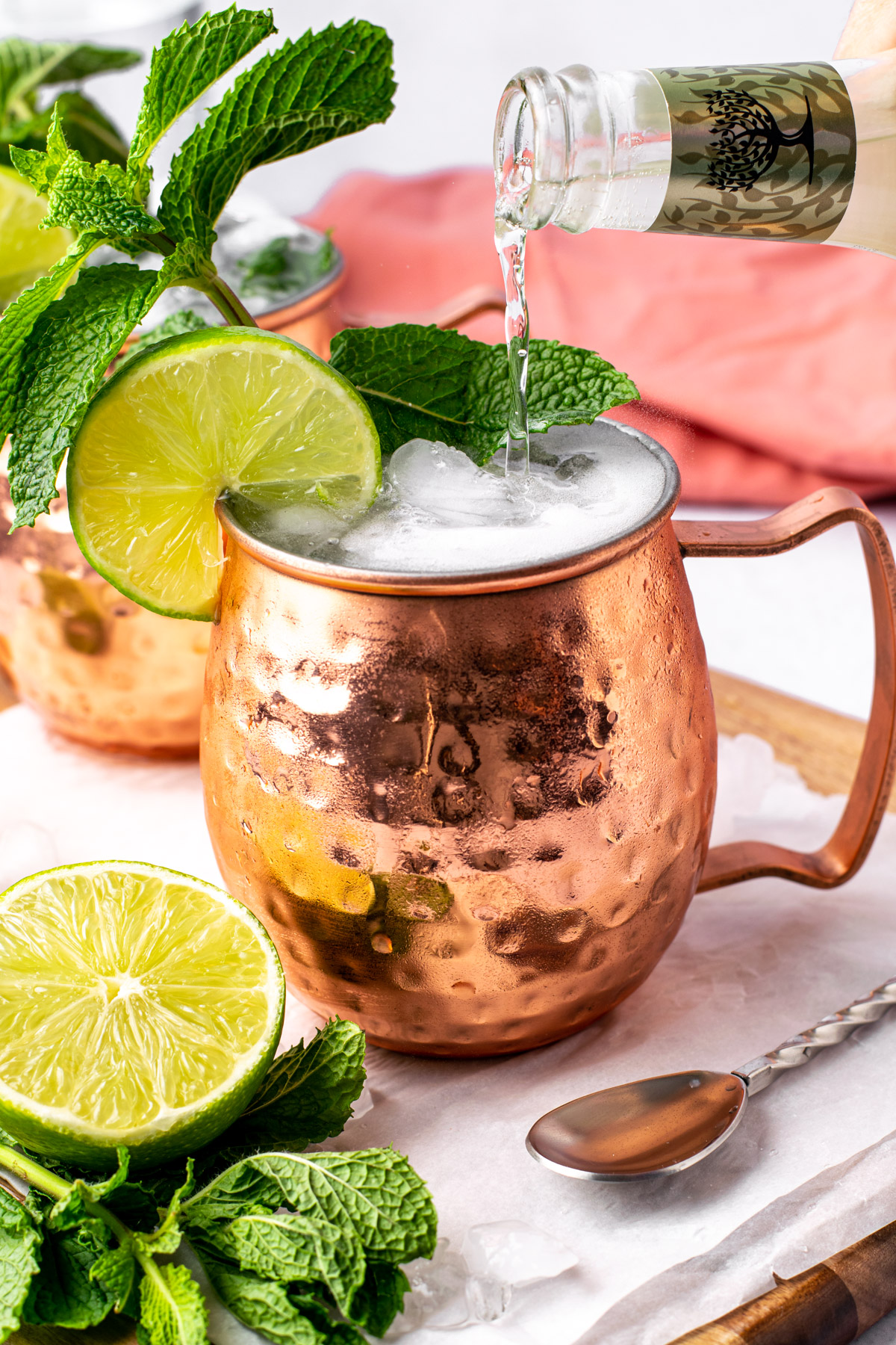 pouring ginger beer into a moscow mule copper cup