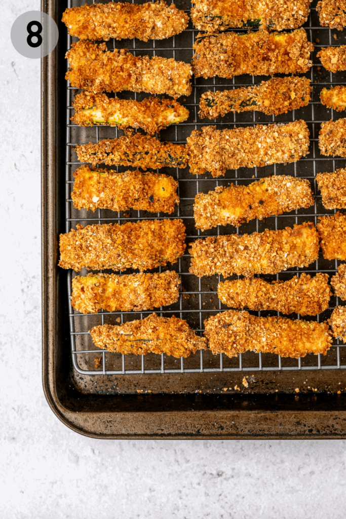 zucchini fries lined up on a baking sheet