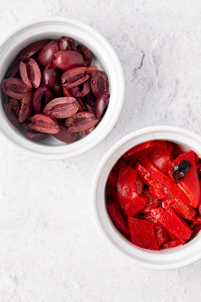 kalamata olives and roasted red peppers in white bowls