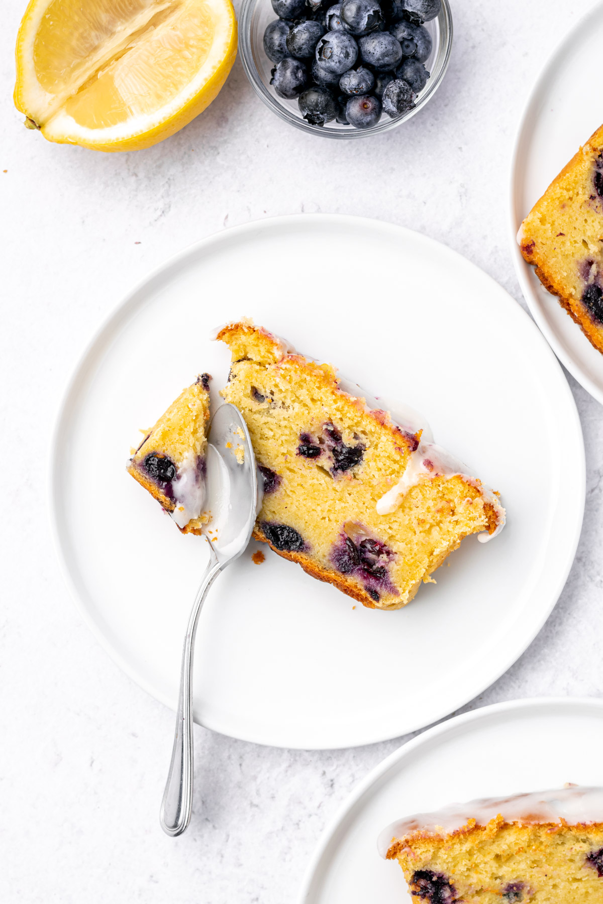 close up of a lemon blueberry bread slice on a white plate