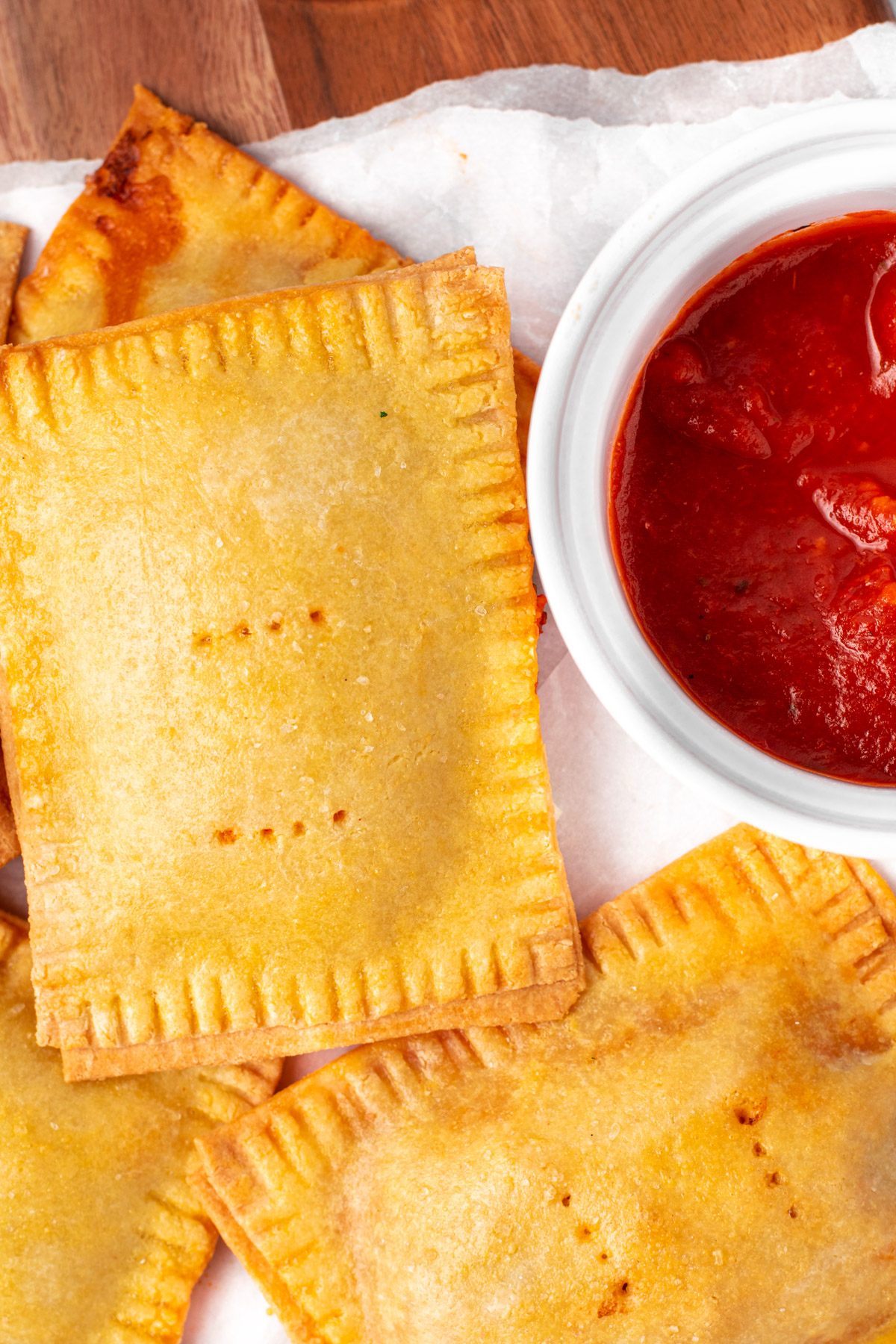 close up of pizza pockets with a cup of sauce