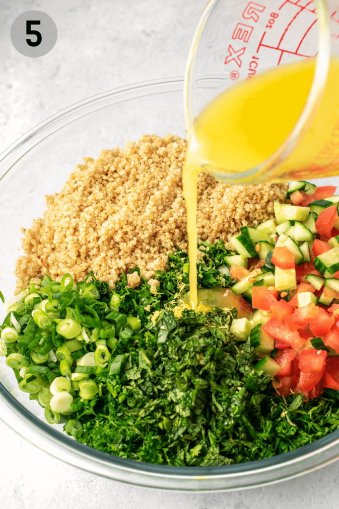 pouring dressing onto quinoa tabbouleh