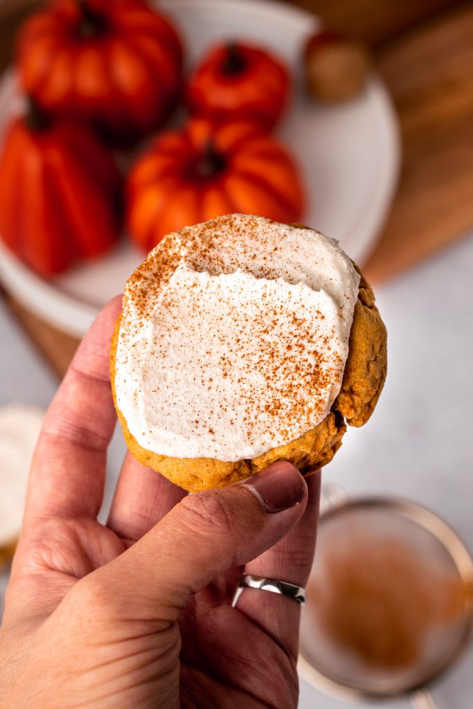 hand holding a pumpkin sugar cookie