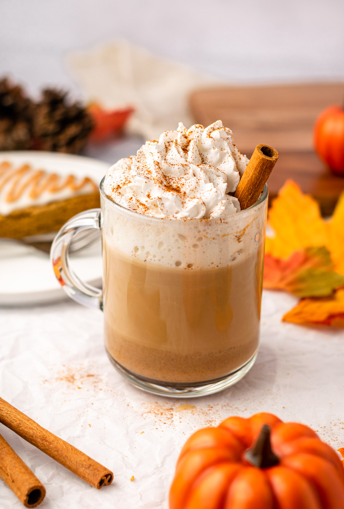 vegan pumpkin spice latte with whipped coconut cream and a cinnamon stick