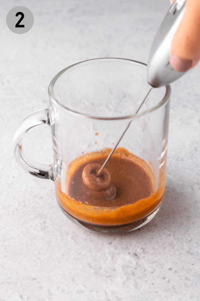 whisking pumpkin sauce in a glass cup