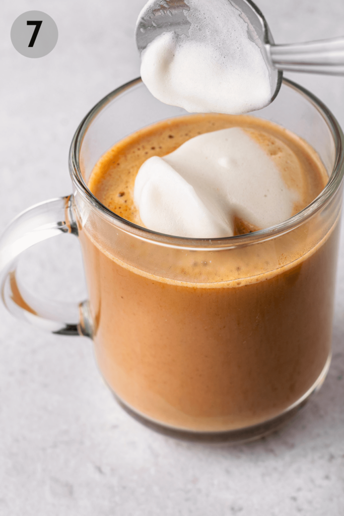 spoon topping latte with milk foam