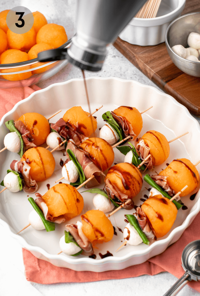 melon prosciutto skewers being drizzled with balsamic glaze