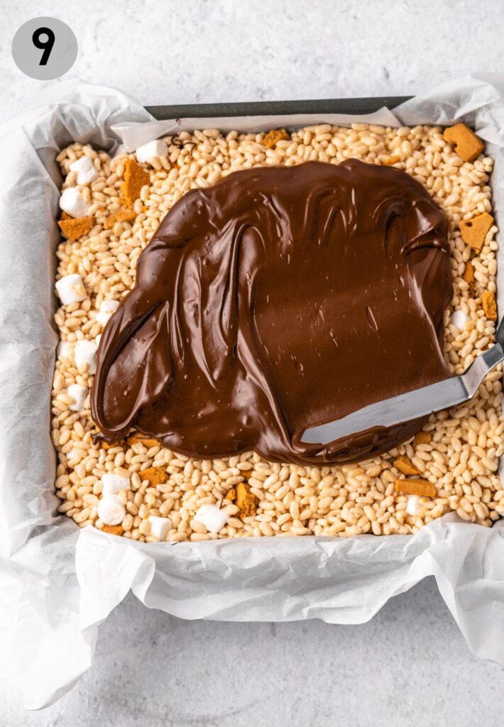 melted chocolate being spread onto s'mores rice crispy treats