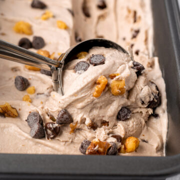 close up of an ice cream scoop scooping vegan chunky monkey ice cream