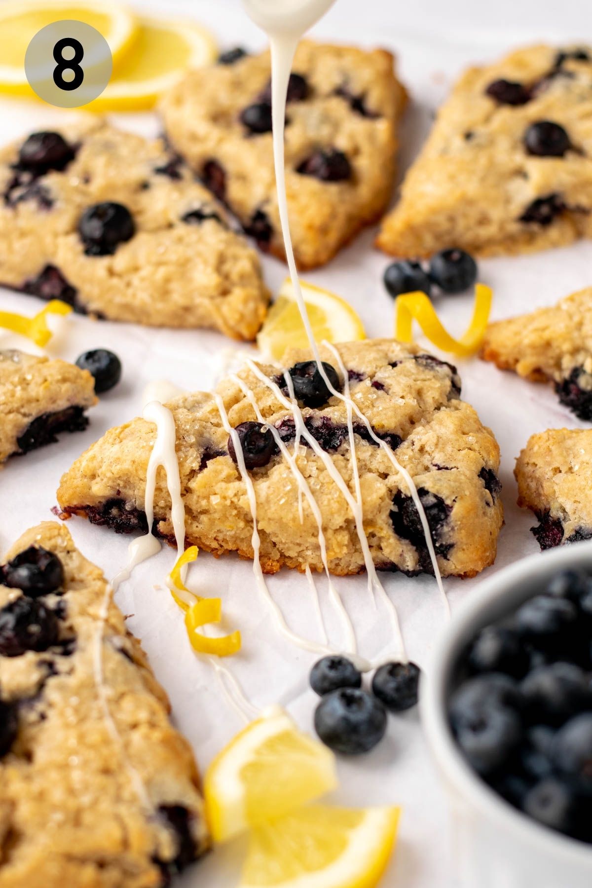 lemon blueberry scone being drizzled with icing