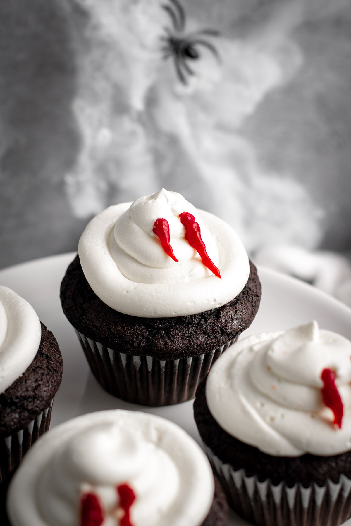 vampire bite cupcake with spider webs in the background.
