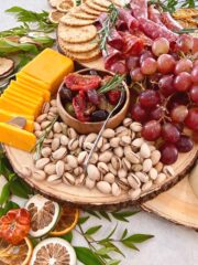 small charcuterie board with nuts, cheese, and grapes.