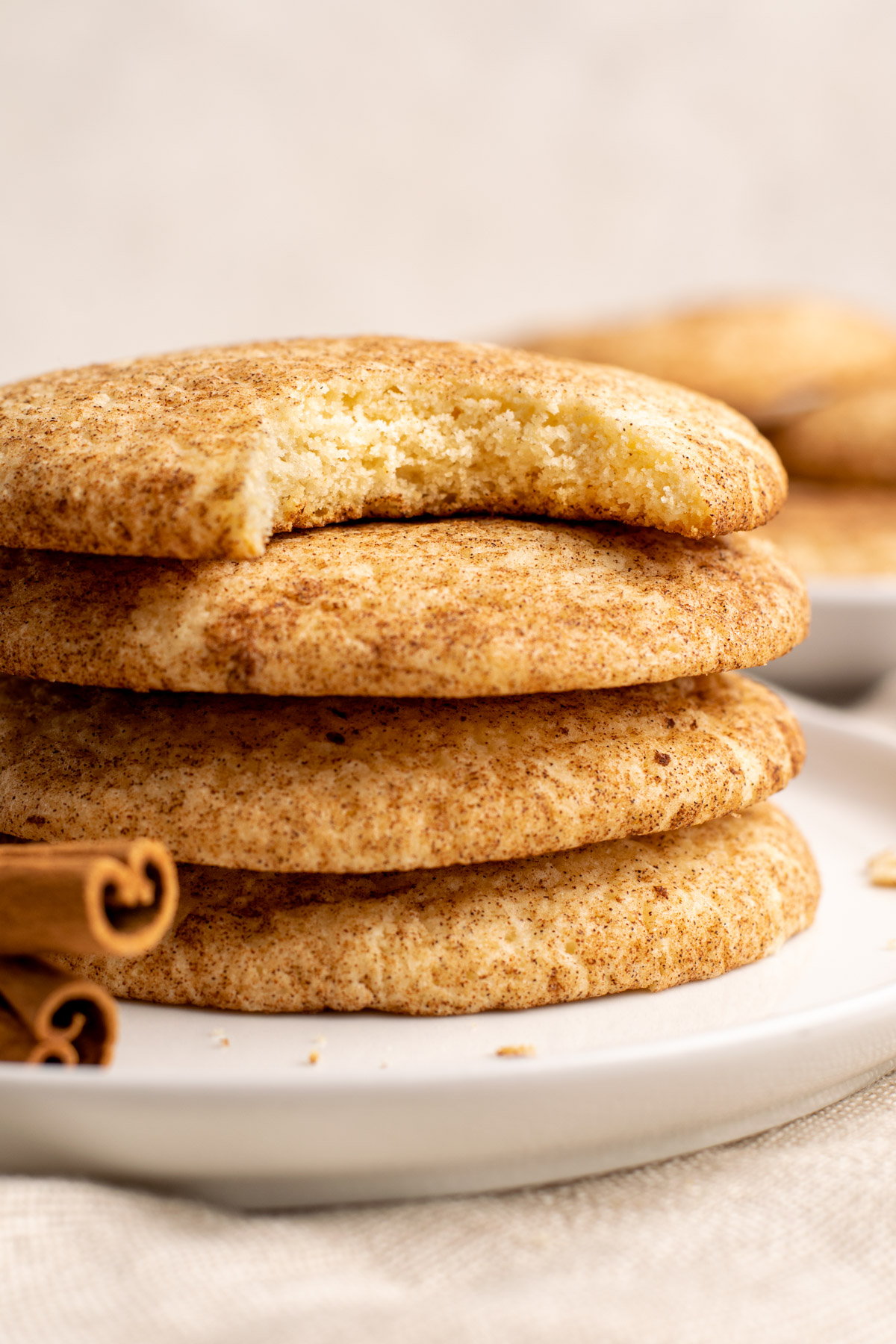 stack of 4 gluten free snickerdoodle cookies, the top one with a bite missing.