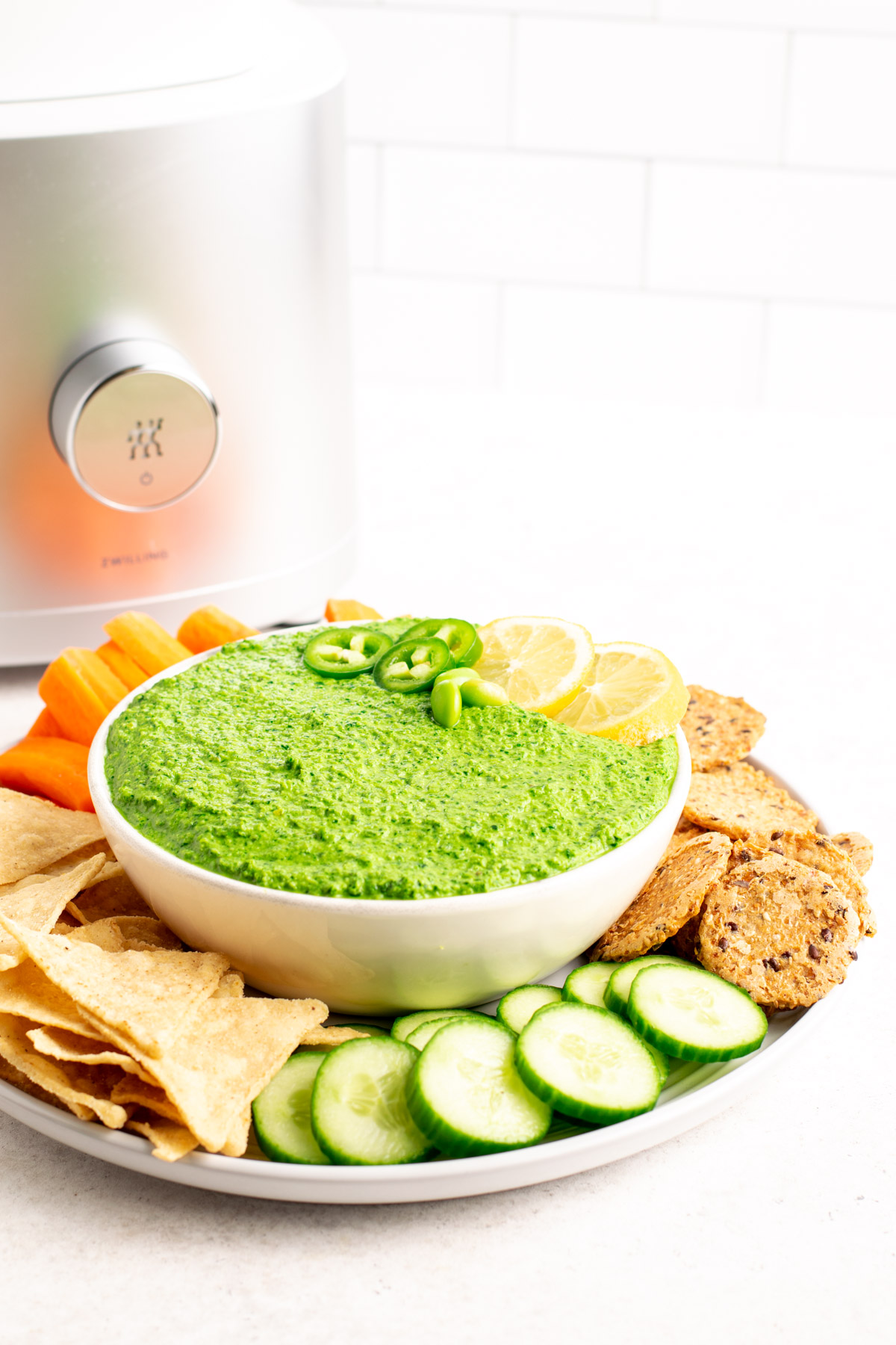 spicy kale edamame dip in a bowl with blender in the background.