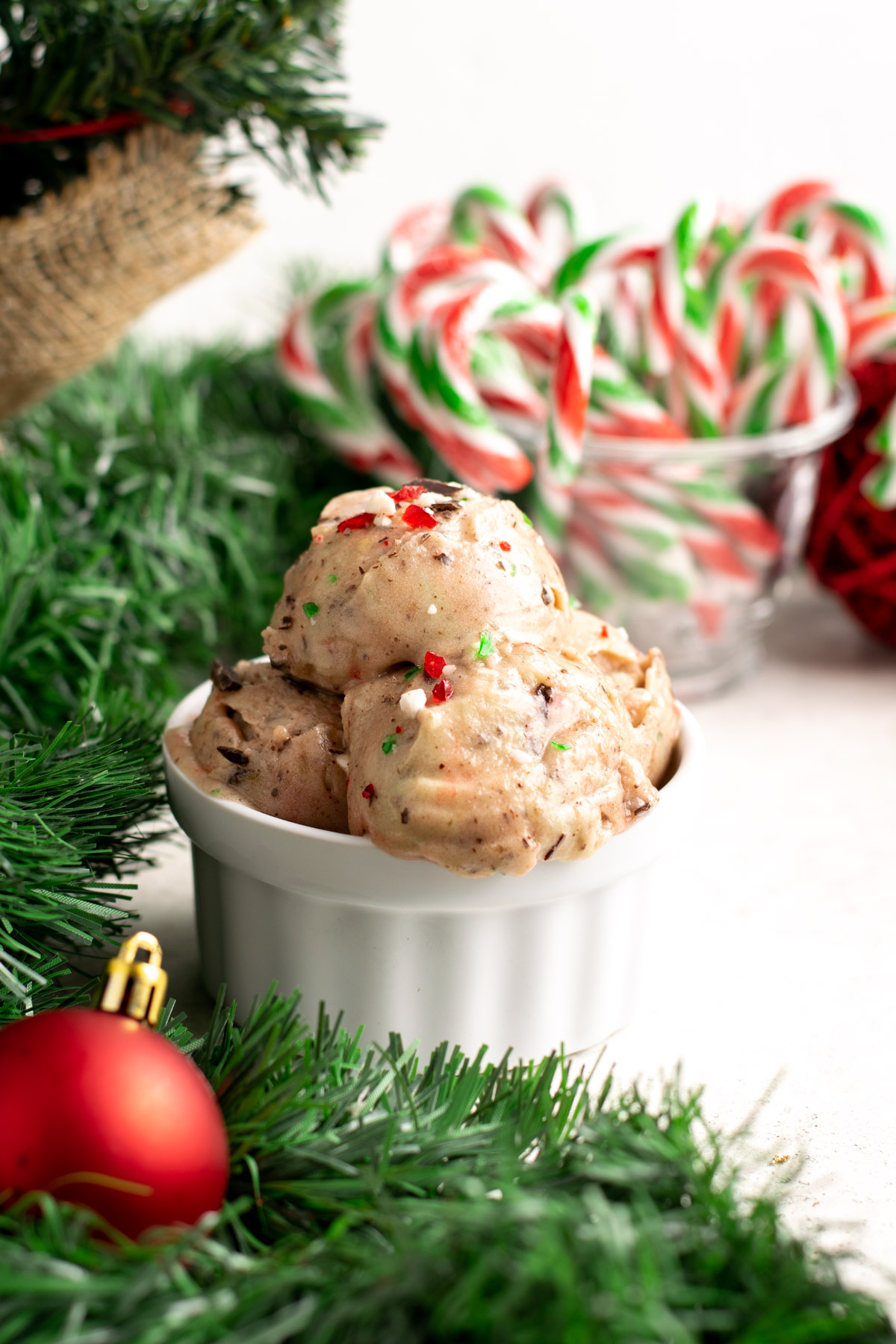 candy cane nice cream scoops in a ramekin surrounded by garland.