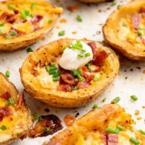 a loaded potato skin topped with chives and sour cream.