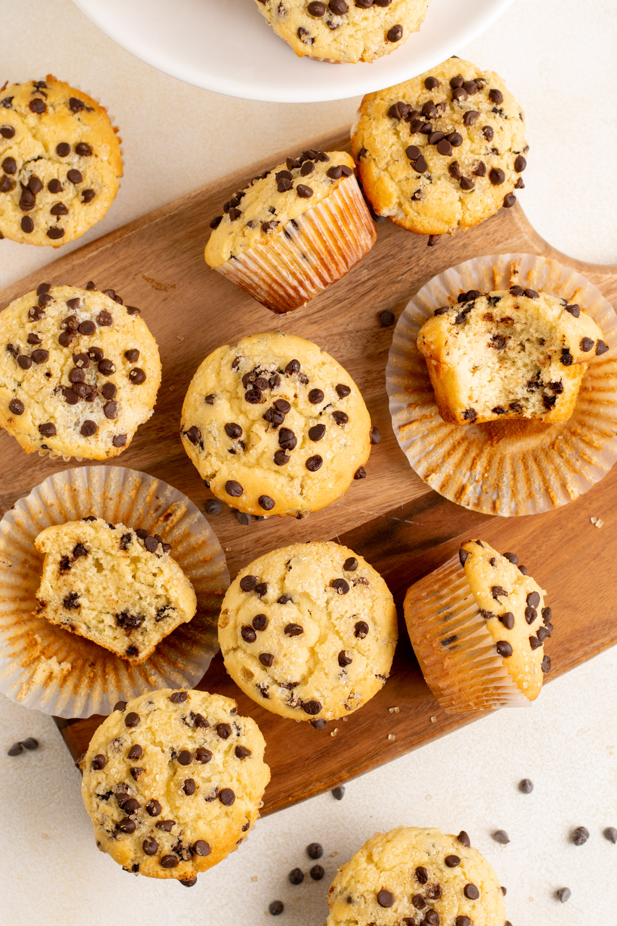 top view of many chocolate chip muffins on a wood board.