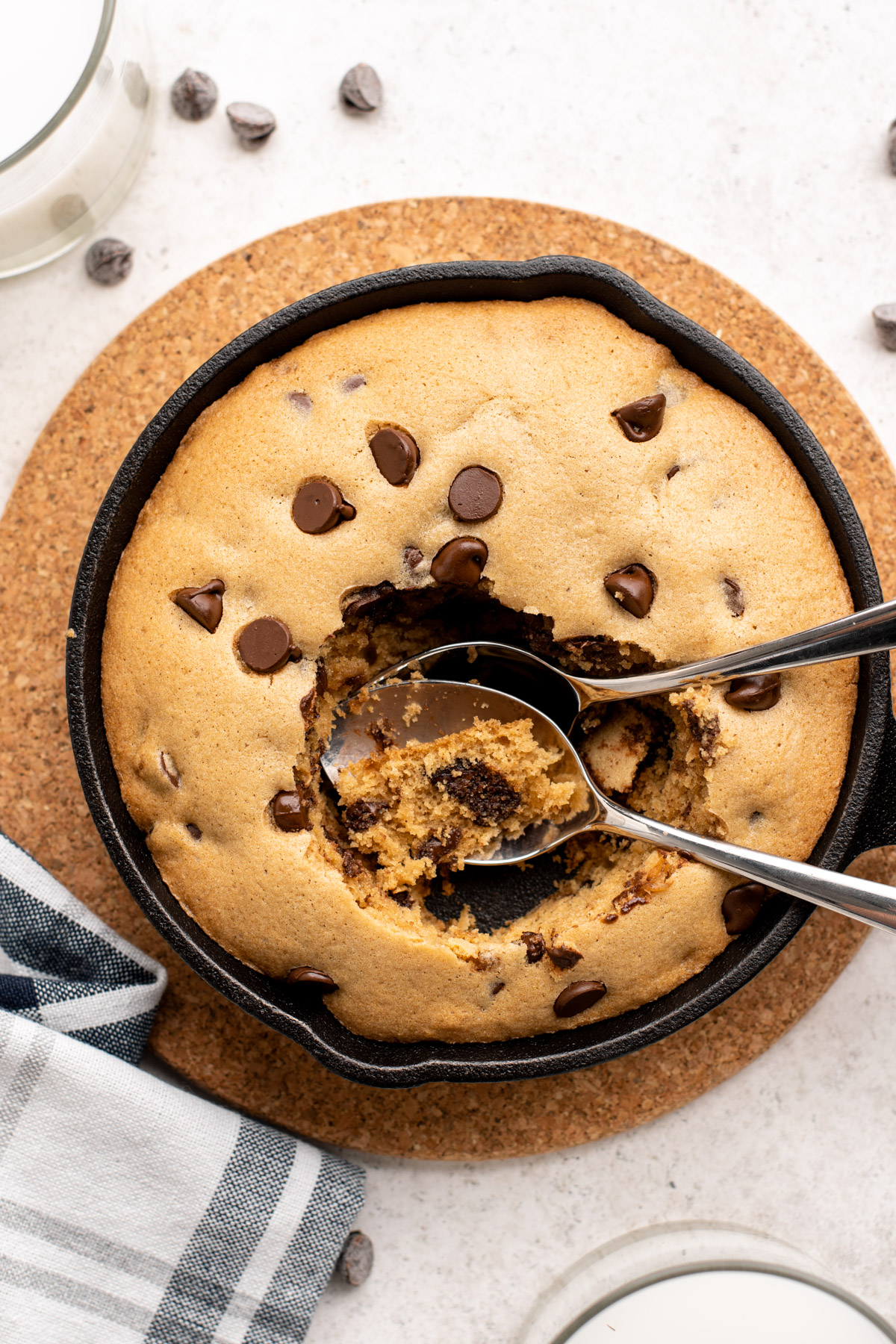 top view of 2 spoons in a cast iron skillet cookie.