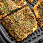 close up of air fried trout in an air fryer basket.