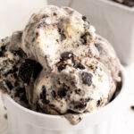 scoops of cookies and cream ice cream in a white ramekin.