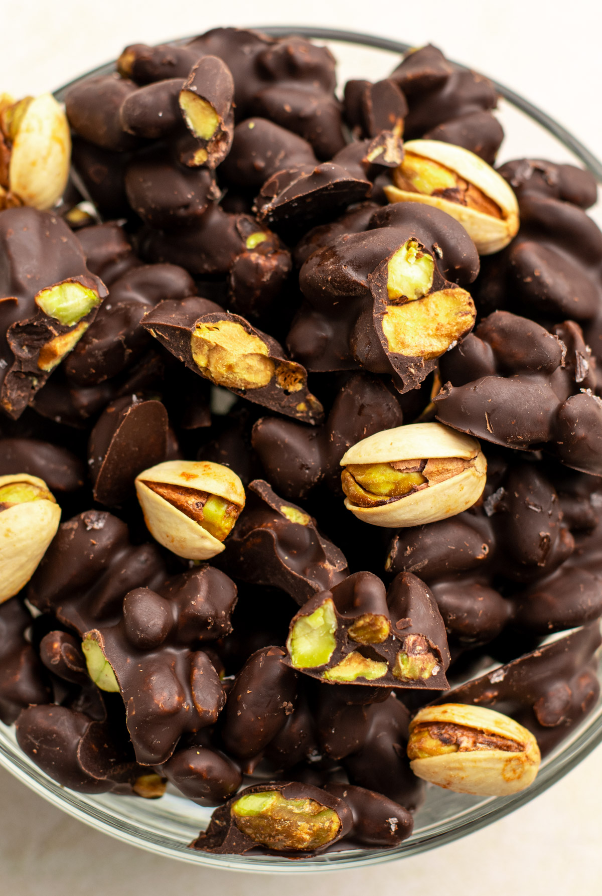 close up of chocolate covered pistachios in a bowl.