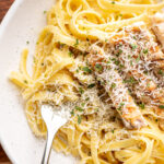 fettuccine alfredo with chicken slices and grated parmesan cheese.