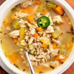 chicken bone broth soup in a white bowl with a spoon.