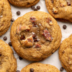 close up of a butter pecan cookie with chocolate chips around.