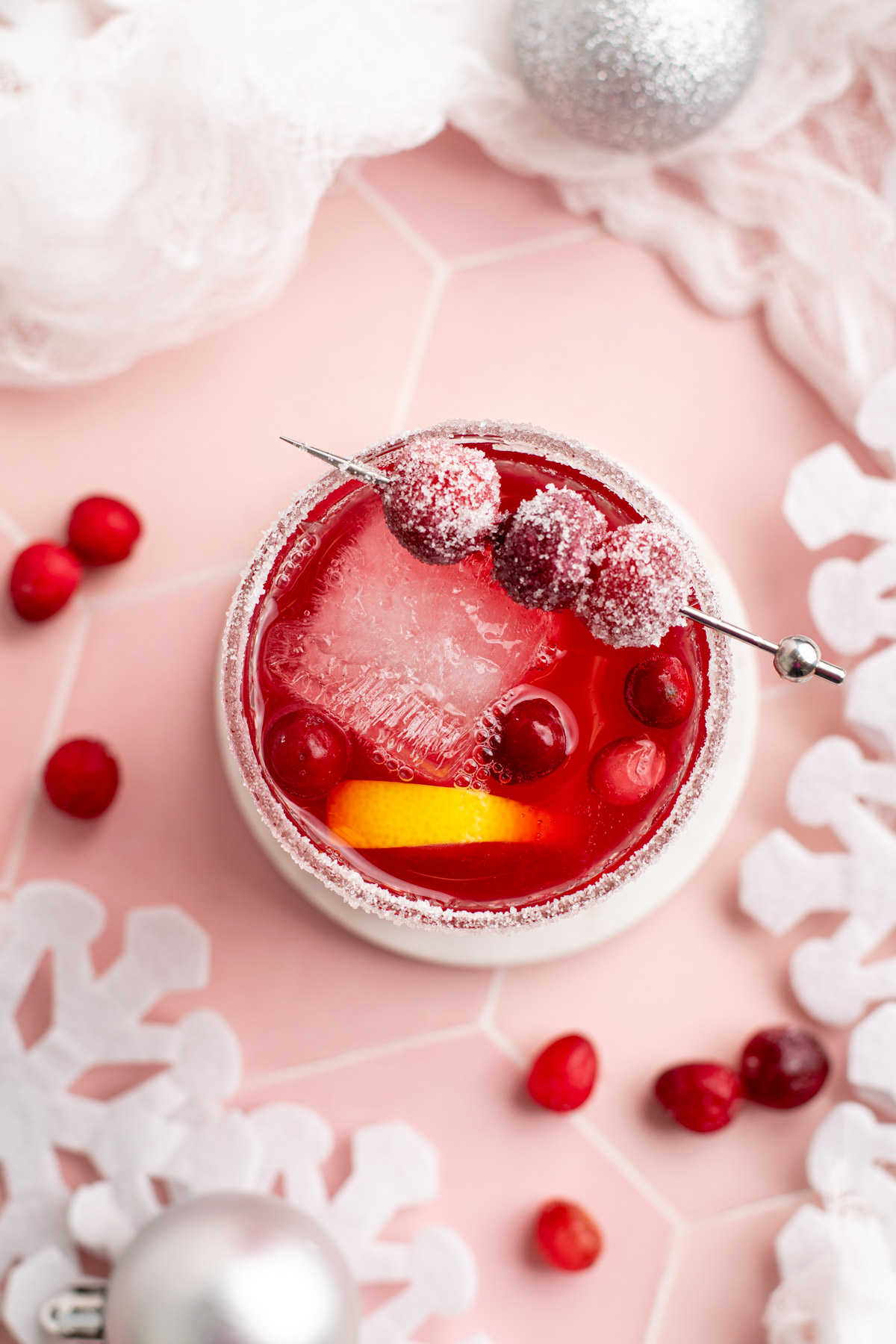 top view of a red drink with cranberries around.