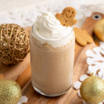 gingerbread protein shake topped with whipped cream and a gingerbread man cookie.