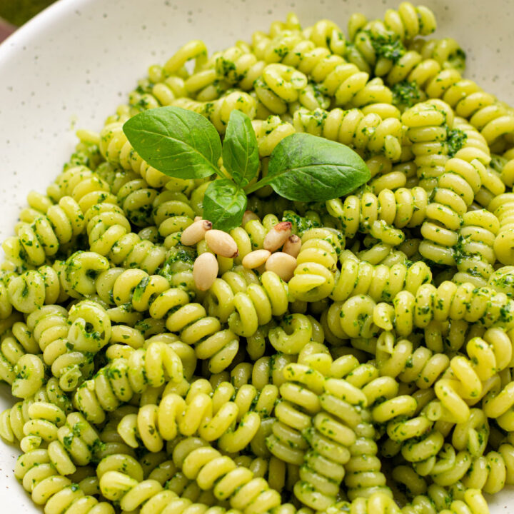 close up of spinach basil pesto on curly pasta.