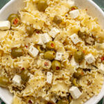 close up of dirty martini pasta salad in a white bowl.