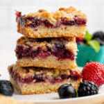 stack of 3 mixed berry crumble bars, side view.
