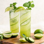 2 cucumber mojito mocktails on a wooden board.