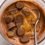 close up of peanut butter chocolate protein ice cream topped with peanut butter and reese cups.