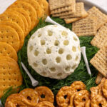 golf ball cheese ball on dill grass with crackers around.
