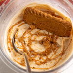 biscoff protein ice cream with a lotus cookie and a spoon.