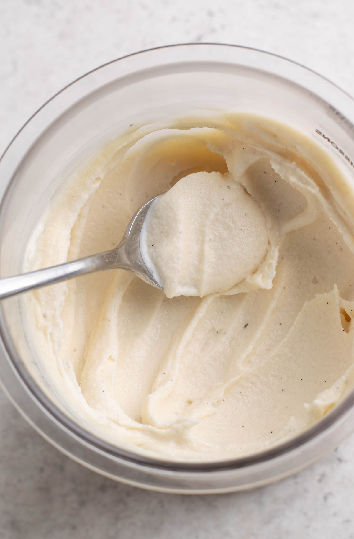 spoon scooping vanilla protein ice cream.