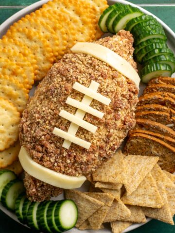 football cheese ball surrounded by crackers.